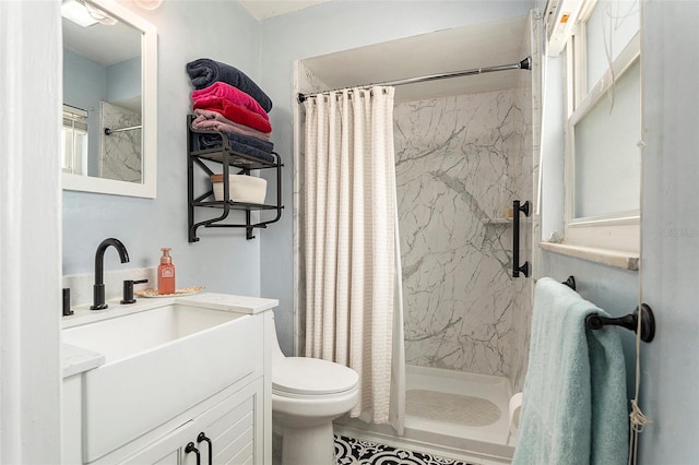 full bath with a stall shower, toilet, and vanity