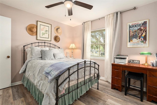 bedroom featuring wood finished floors, baseboards, and a ceiling fan
