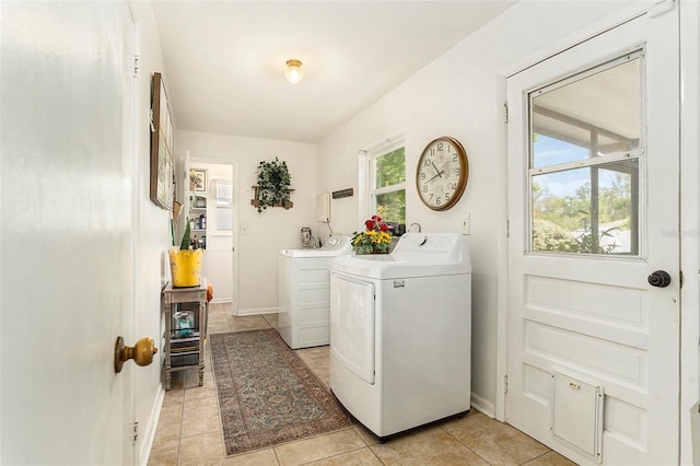 laundry room featuring separate washer and dryer, baseboards, and light tile patterned flooring