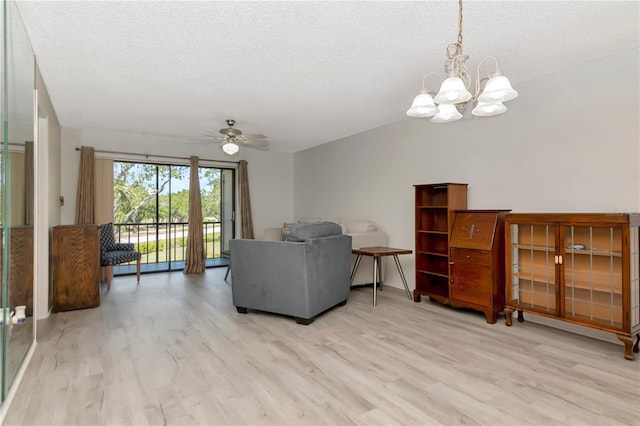 112 W Cypress Ct, Oldsmar, FL 34677 - living area with a textured ceiling, light wood-style flooring, and ceiling fan with notable chandelier
