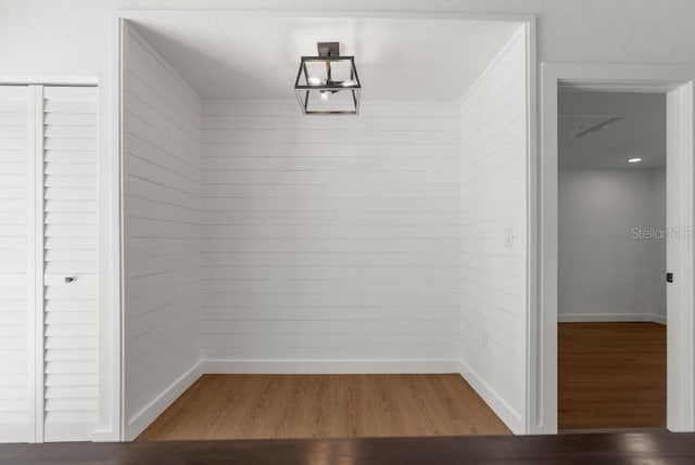 unfurnished dining area featuring baseboards and wood finished floors