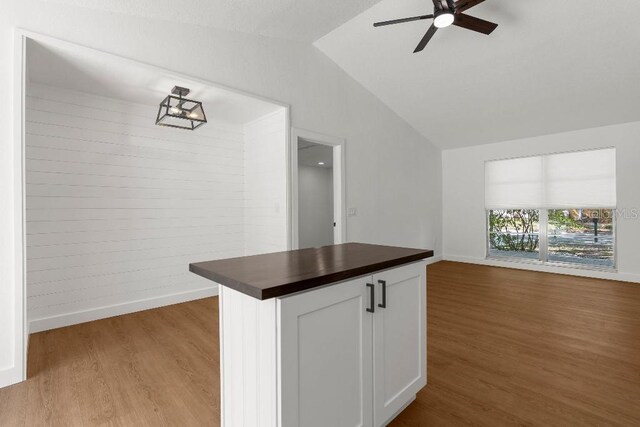 kitchen featuring ceiling fan, wooden counters, open floor plan, wood finished floors, and lofted ceiling