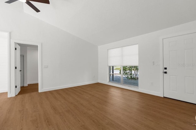unfurnished living room featuring baseboards, ceiling fan, wood finished floors, and lofted ceiling