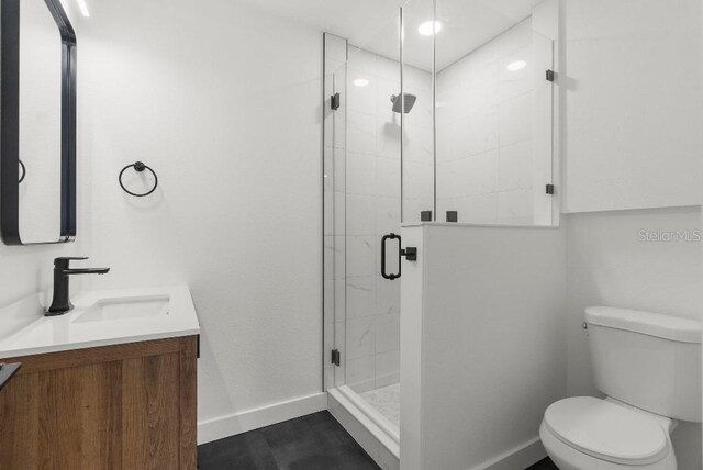bathroom with baseboards, a shower stall, vanity, and toilet