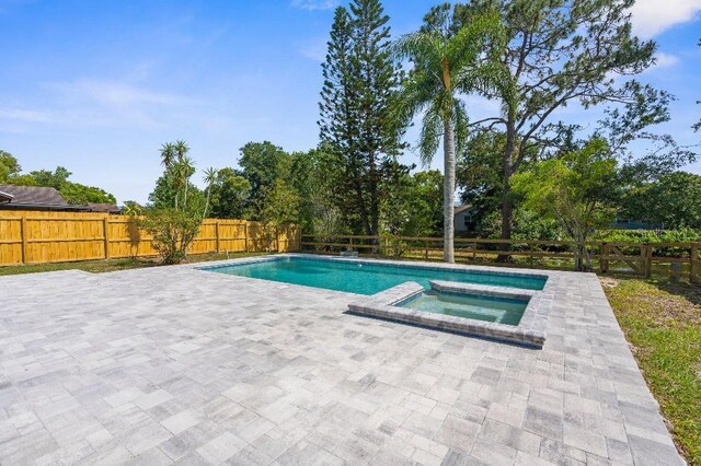 view of swimming pool featuring a fenced backyard, a patio, and a pool with connected hot tub