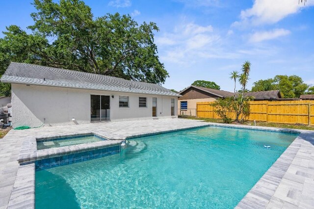 view of swimming pool featuring a fenced backyard, a patio area, and a pool with connected hot tub