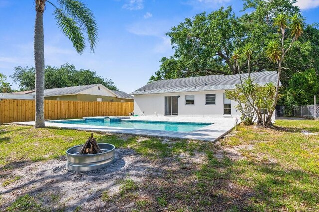 view of swimming pool with a fenced backyard, a fenced in pool, a fire pit, and a patio area