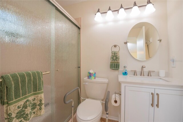 bathroom featuring a shower with door, toilet, vanity, and baseboards