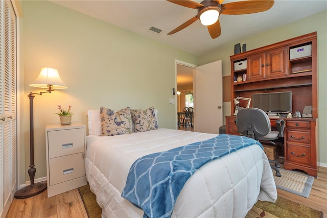 bedroom featuring light wood-style flooring, an office area, and baseboards