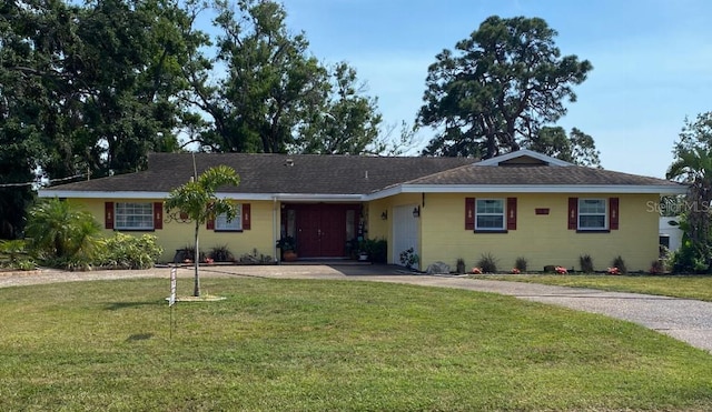 ranch-style house featuring a front lawn, roof with shingles, and driveway