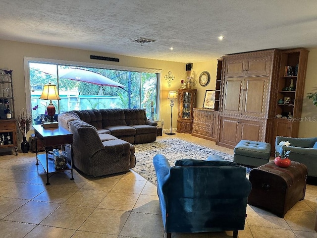 living area with recessed lighting, a textured ceiling, visible vents, and light tile patterned floors