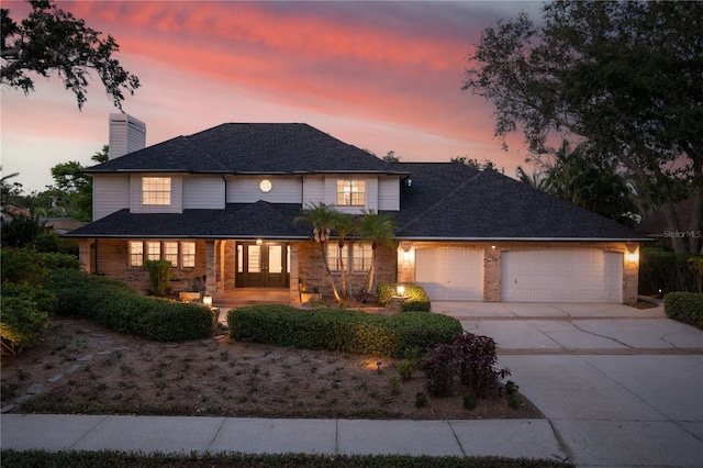 101 Ponce De Leon Blvd, Belleair, FL 33756 - view of front of home featuring french doors, a garage, a chimney, concrete driveway, and brick siding
