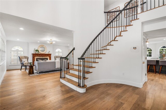101 Ponce De Leon Blvd, Belleair, FL 33756 - staircase with baseboards, a wealth of natural light, a glass covered fireplace, and wood finished floors