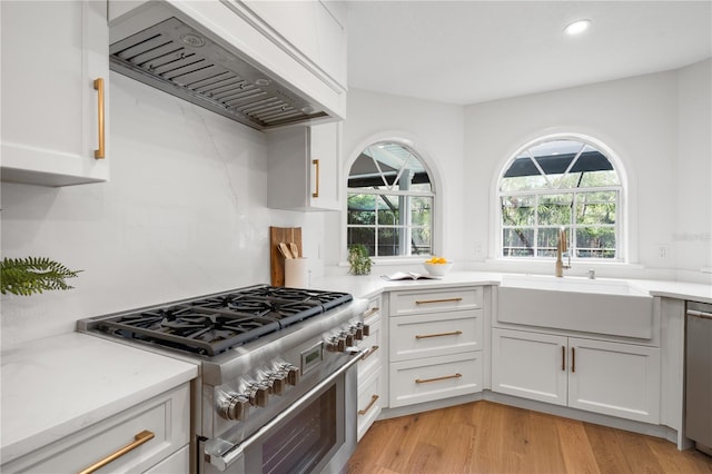 101 Ponce De Leon Blvd, Belleair, FL 33756 - kitchen with a sink, white cabinets, custom range hood, and appliances with stainless steel finishes