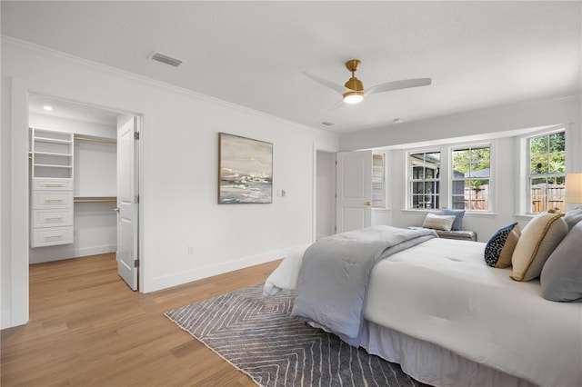 101 Ponce De Leon Blvd, Belleair, FL 33756 - bedroom featuring baseboards, light wood finished floors, visible vents, crown molding, and a walk in closet