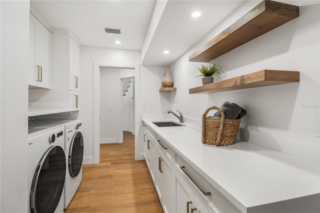 101 Ponce De Leon Blvd, Belleair, FL 33756 - laundry room with a sink, cabinet space, washer and clothes dryer, visible vents, and light wood-style floors