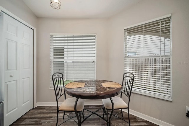 dining room with baseboards and dark wood-type flooring