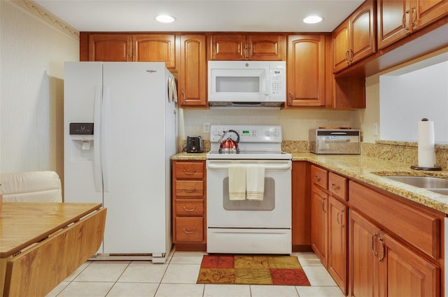 2595 Countryside Blvd Unit 8205, Clearwater, FL 33761 - kitchen featuring light stone countertops, brown cabinets, light tile patterned flooring, recessed lighting, and white appliances