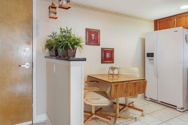 2595 Countryside Blvd Unit 8205, Clearwater, FL 33761 - kitchen featuring light tile patterned floors, white fridge with ice dispenser, and brown cabinets