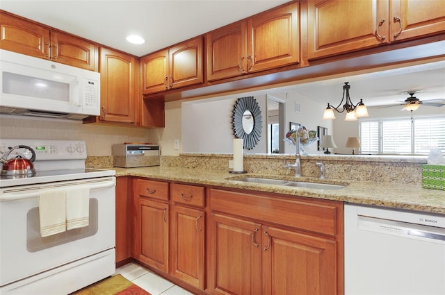 2595 Countryside Blvd Unit 8205, Clearwater, FL 33761 - kitchen with white appliances, light stone countertops, brown cabinetry, and a sink
