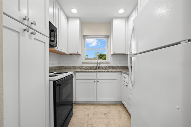 381 S Mcmullen Booth Rd Unit 72, Clearwater, FL 33759 - kitchen featuring decorative backsplash, range with electric stovetop, black microwave, a sink, and freestanding refrigerator