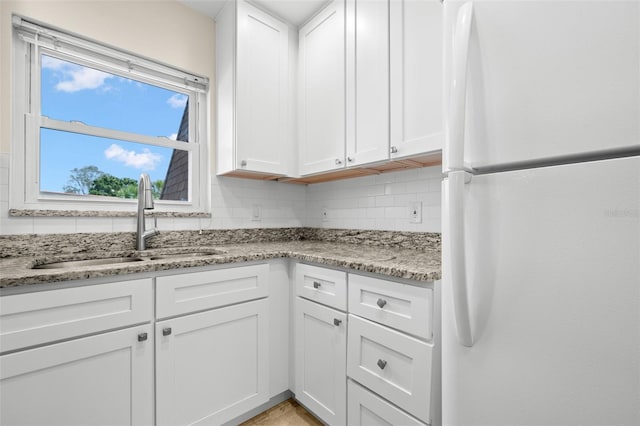 381 S Mcmullen Booth Rd Unit 72, Clearwater, FL 33759 - kitchen featuring freestanding refrigerator, a sink, white cabinetry, and light stone countertops