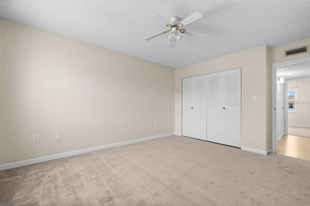 381 S Mcmullen Booth Rd Unit 72, Clearwater, FL 33759 - unfurnished bedroom with carpet flooring, a textured ceiling, baseboards, visible vents, and a closet
