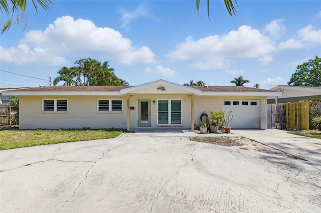 single story home featuring fence, an attached garage, and driveway