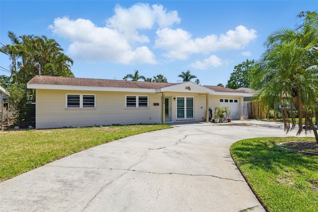 ranch-style house with an attached garage, driveway, and a front yard