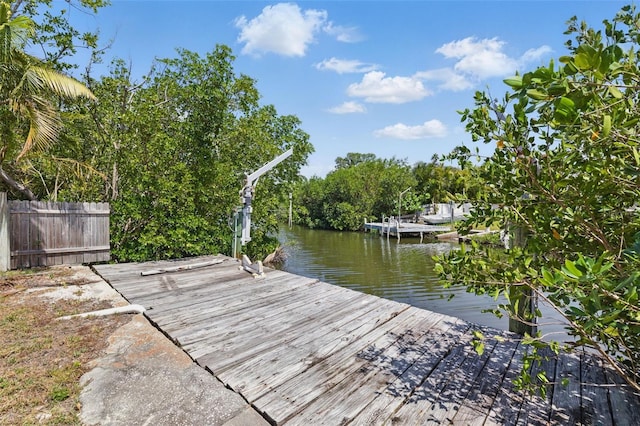 dock area with a water view and fence