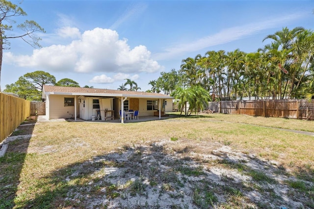 rear view of property featuring a lawn, a fenced backyard, a patio area, and stucco siding