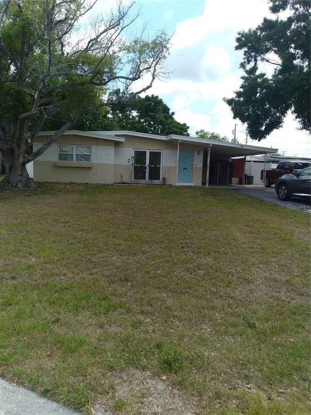 single story home with a front lawn, aphalt driveway, and a carport