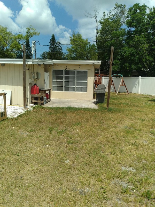 back of property with fence, a patio, and a yard