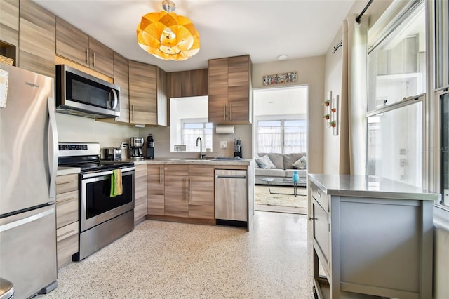 3626 17th St N, Saint Petersburg, FL 33713 - kitchen featuring brown cabinets, a sink, modern cabinets, appliances with stainless steel finishes, and light speckled floor