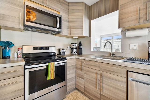 3626 17th St N, Saint Petersburg, FL 33713 - kitchen featuring stainless steel appliances, modern cabinets, a sink, light speckled floor, and light countertops