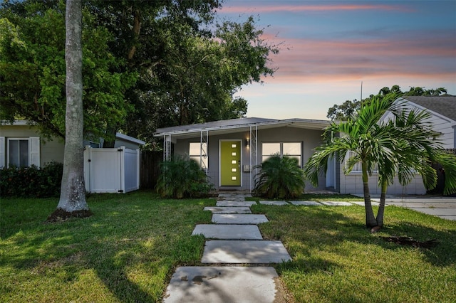 3626 17th St N, Saint Petersburg, FL 33713 - view of front of property with a yard, fence, stucco siding, and concrete driveway