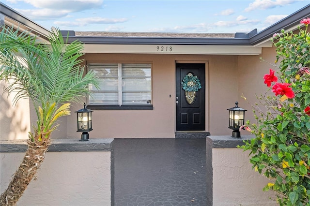 property entrance featuring stucco siding and covered porch