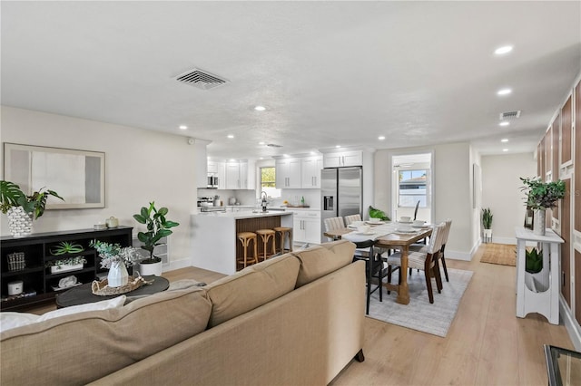living area with baseboards, recessed lighting, and visible vents