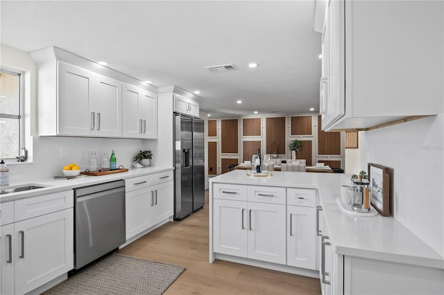 kitchen with light countertops, appliances with stainless steel finishes, white cabinets, and recessed lighting