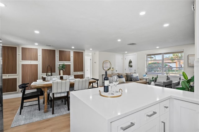 kitchen featuring white cabinets, light wood finished floors, light countertops, recessed lighting, and visible vents