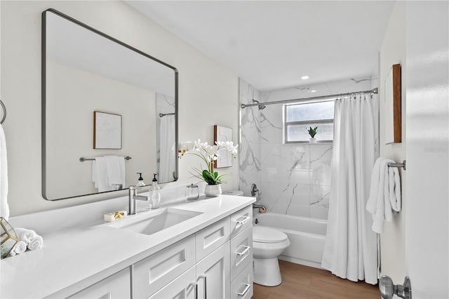 full bath with vanity, wood finished floors, shower / bath combo, and toilet