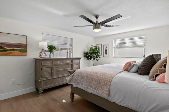 bedroom with baseboards, a ceiling fan, and wood finished floors