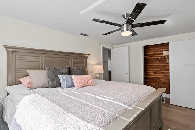 bedroom featuring visible vents, ceiling fan, and wood finished floors