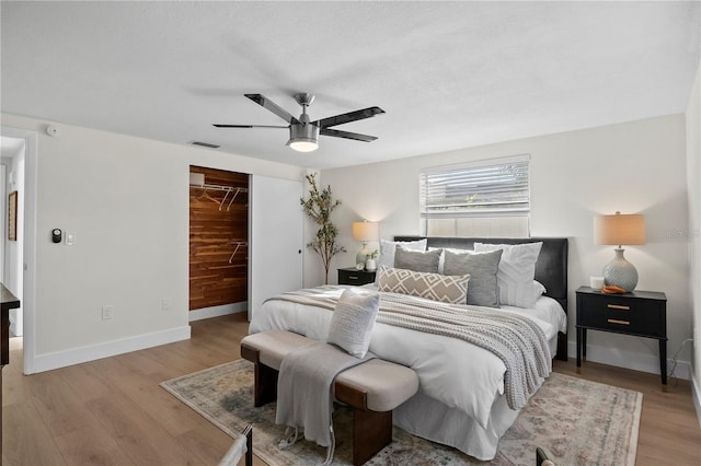 bedroom with a ceiling fan, visible vents, baseboards, a closet, and light wood finished floors