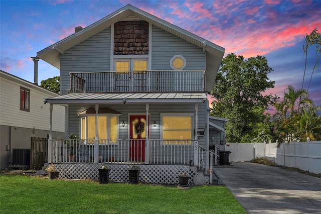 757 32nd Ave N, Saint Petersburg, FL 33704 - view of front facade featuring fence, a front lawn, a porch, a standing seam roof, and driveway