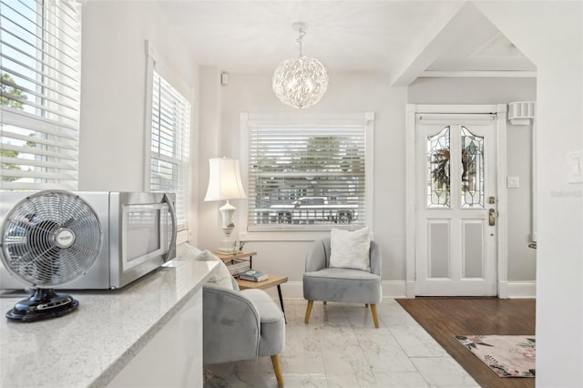 757 32nd Ave N, Saint Petersburg, FL 33704 - sitting room featuring baseboards, an inviting chandelier, plenty of natural light, and marble finish floor