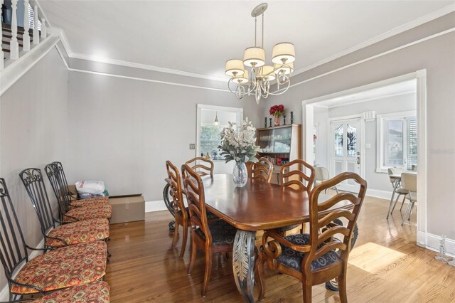 757 32nd Ave N, Saint Petersburg, FL 33704 - dining space with an inviting chandelier, ornamental molding, light wood finished floors, and baseboards