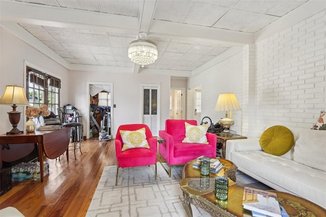 757 32nd Ave N, Saint Petersburg, FL 33704 - living room featuring brick wall, a chandelier, and wood finished floors