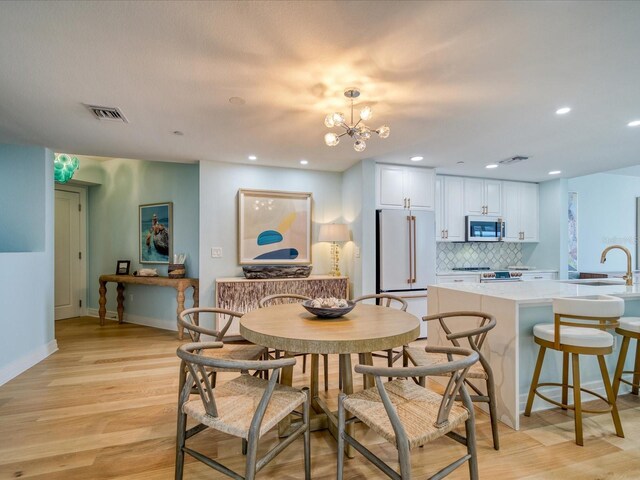 331 Cleveland St # 1806, Clearwater, FL 33755 - dining room featuring visible vents, light wood finished floors, baseboards, and a chandelier