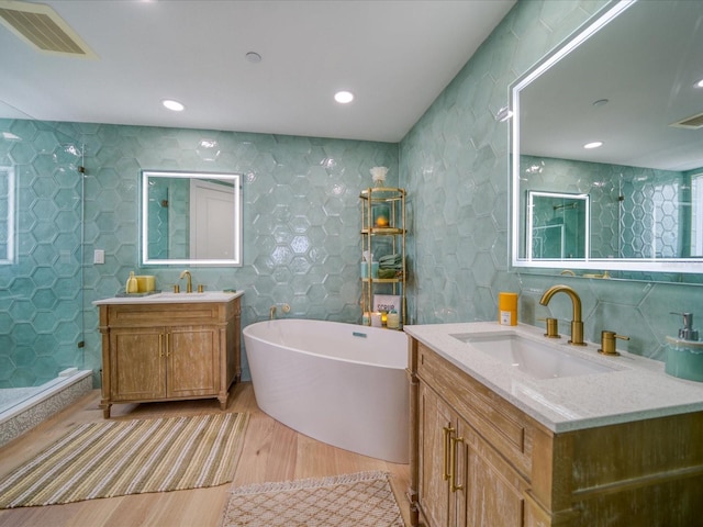 331 Cleveland St # 1806, Clearwater, FL 33755 - full bathroom with a freestanding bath, a sink, wood finished floors, visible vents, and a stall shower